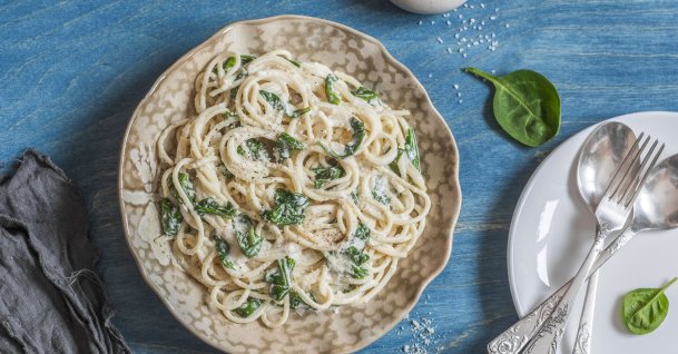 You can add parmesan while serving creamy spinach spaghetti. (Shutterstock) 