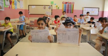 Students pose with their report card following the end of the school year, Mardin, southeastern Türkiye, June 14, 2024. (AA Photo)