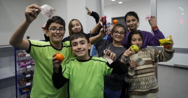 Students pose with canteen products and money at the Mustafa Canlı Science and Art Center in Gümüşhane, northern Türkiye, Dec. 11, 2024. (IHA Photo)