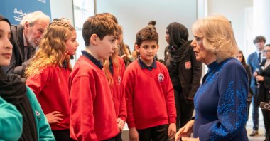 Britain&#039;s Queen Camilla (R) speaks with school children as she attends a reception, hosted by the Anne Frank Trust to mark Holocaust Memorial Day, Hilton Park Lane, London, U.K., Jan. 23, 2025. (AFP Photo)