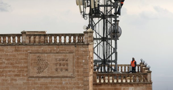 Türk Telekom technicians work on a telecommunications tower atop a historic building in Mardin, southeastern Türkiye, Dec. 29, 2024. (DHA Photo)