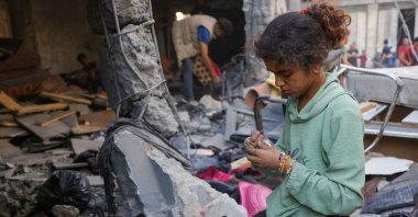 A girl collects belongings as Palestinians check the site of an overnight Israeli strike, in Jabalia, Gaza Strip, Palestine, May 30, 2025. (AFP Photo)