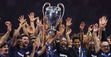Paris Saint-Germain captain Marquinhos hoists the Champions League trophy alongside teammates, club president Nasser Al-Khelaifi, and sporting director Luis Campos during the victory parade at Parc des Princes, Paris, France, June 1, 2025. (Reuters Photo)