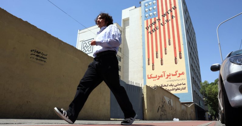 An Iranian man walks past an anti-U.S. mural in Tehran, Iran, May 21, 2025. (EPA Photo)