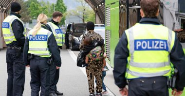 A Nigerian woman and her two children are escorted by German federal police officers after being required to disembark from a tourist bus at the Kiefersfelden border control station in southern Germany, upon entering from Austria, May 9, 2025. (AFP File Photo)